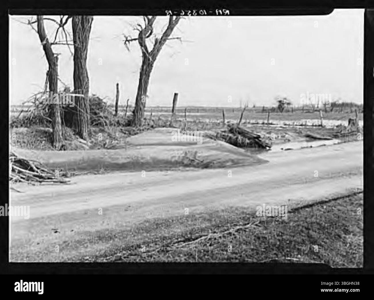 During the 1937 flood, soil was washed away from a field and deposited on the road, showcasing the significant erosion and land displacement caused by the floodwaters. Stock Photo