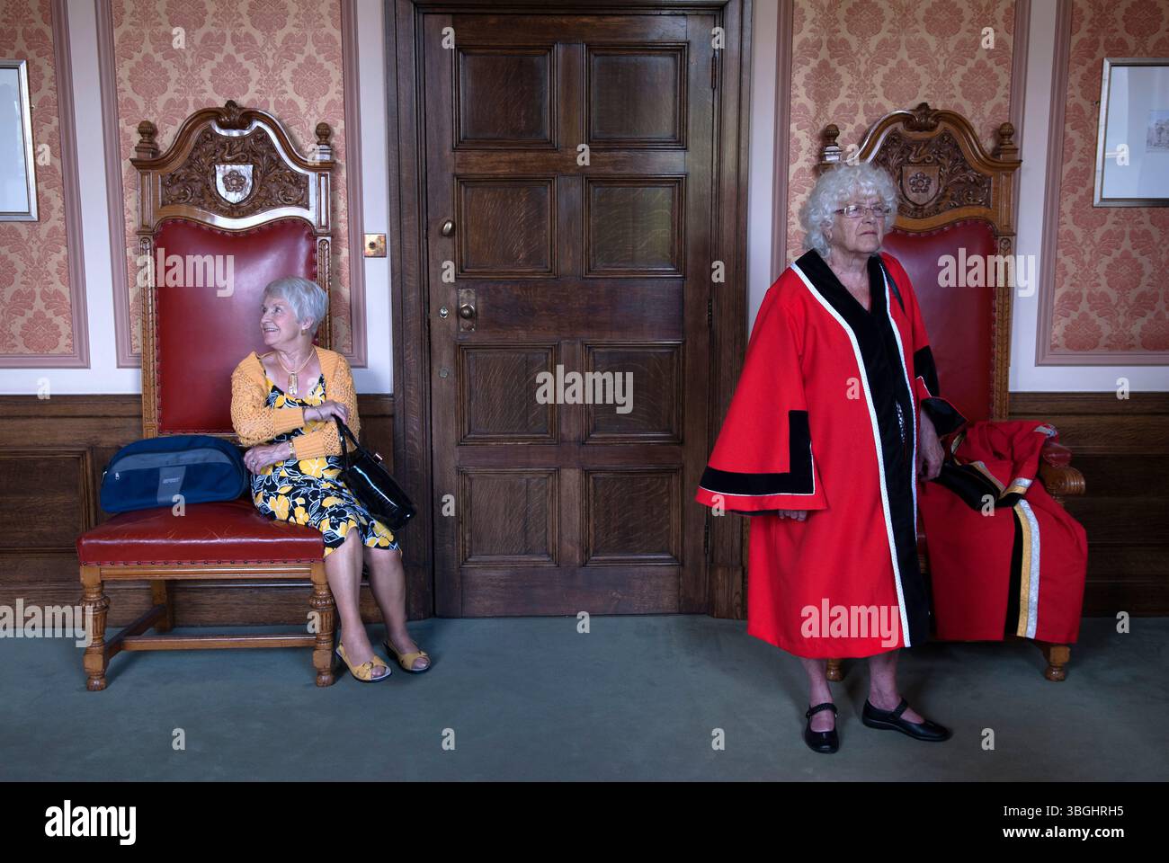 Mayors Chairs in the mayors parlour, Leicester town hall. Two member of the Guild Of Freemen getting ready for the Damask Rose annual ceremony. Leicestershire England 2016 UK 2010s HOMER SYKES Stock Photo