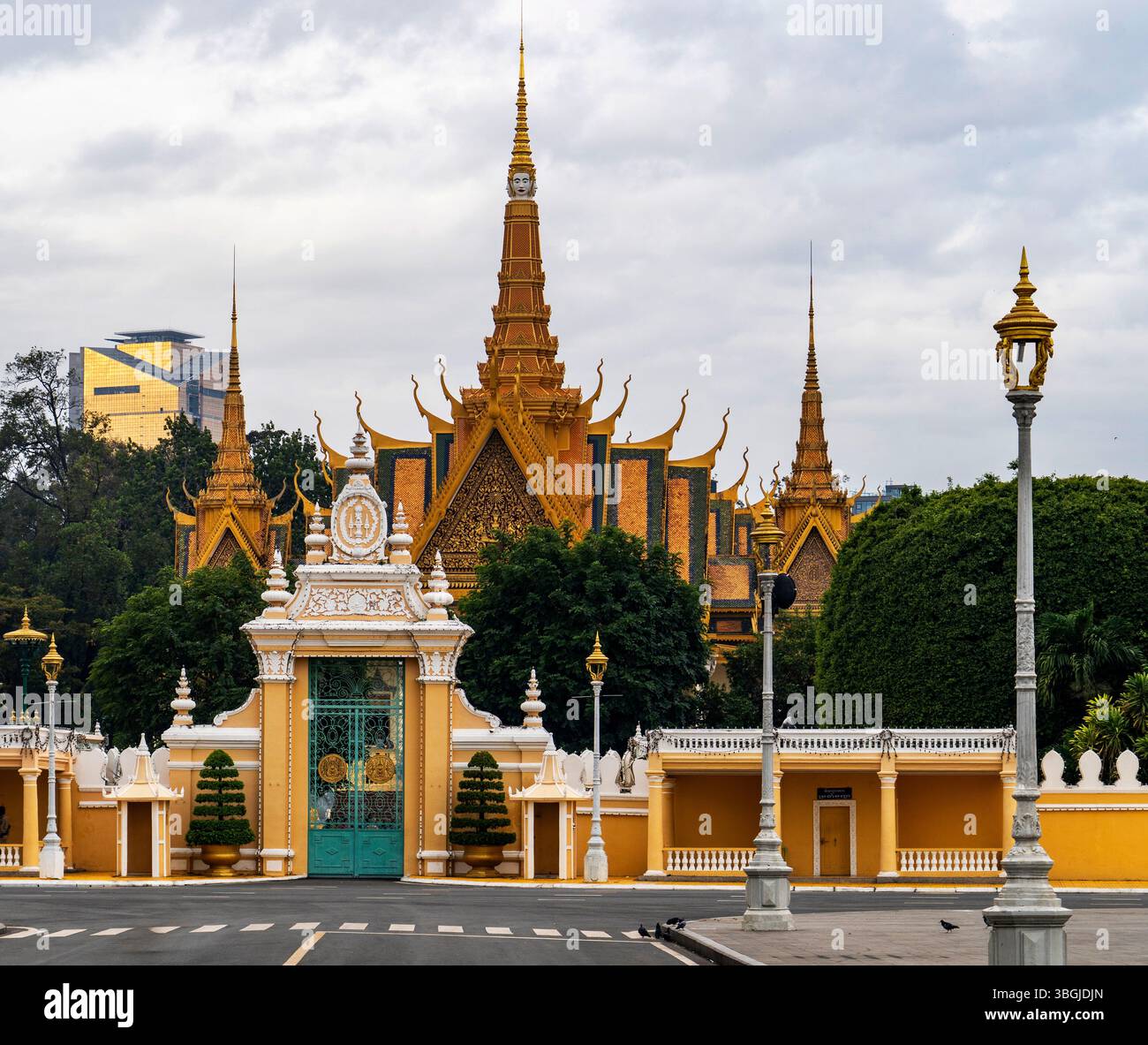 A stunning view of a royal palace with intricate architecture, featuring golden spires and ornate decorations. The palace is surrounded by lush greene Stock Photo