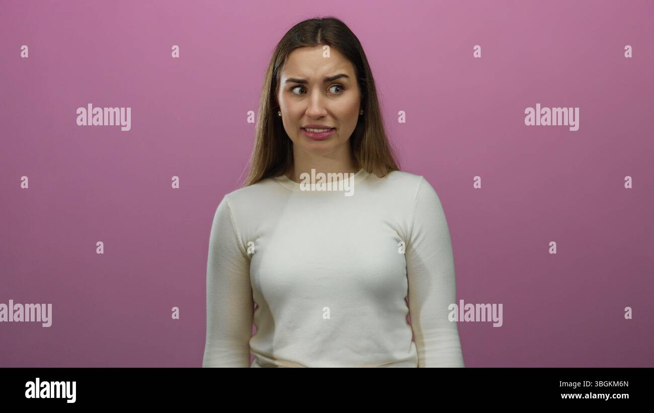 Woman expressing different emotions against an isolated pink background wall showcasing a range of facial expressions including confusion and frustrat Stock Photo