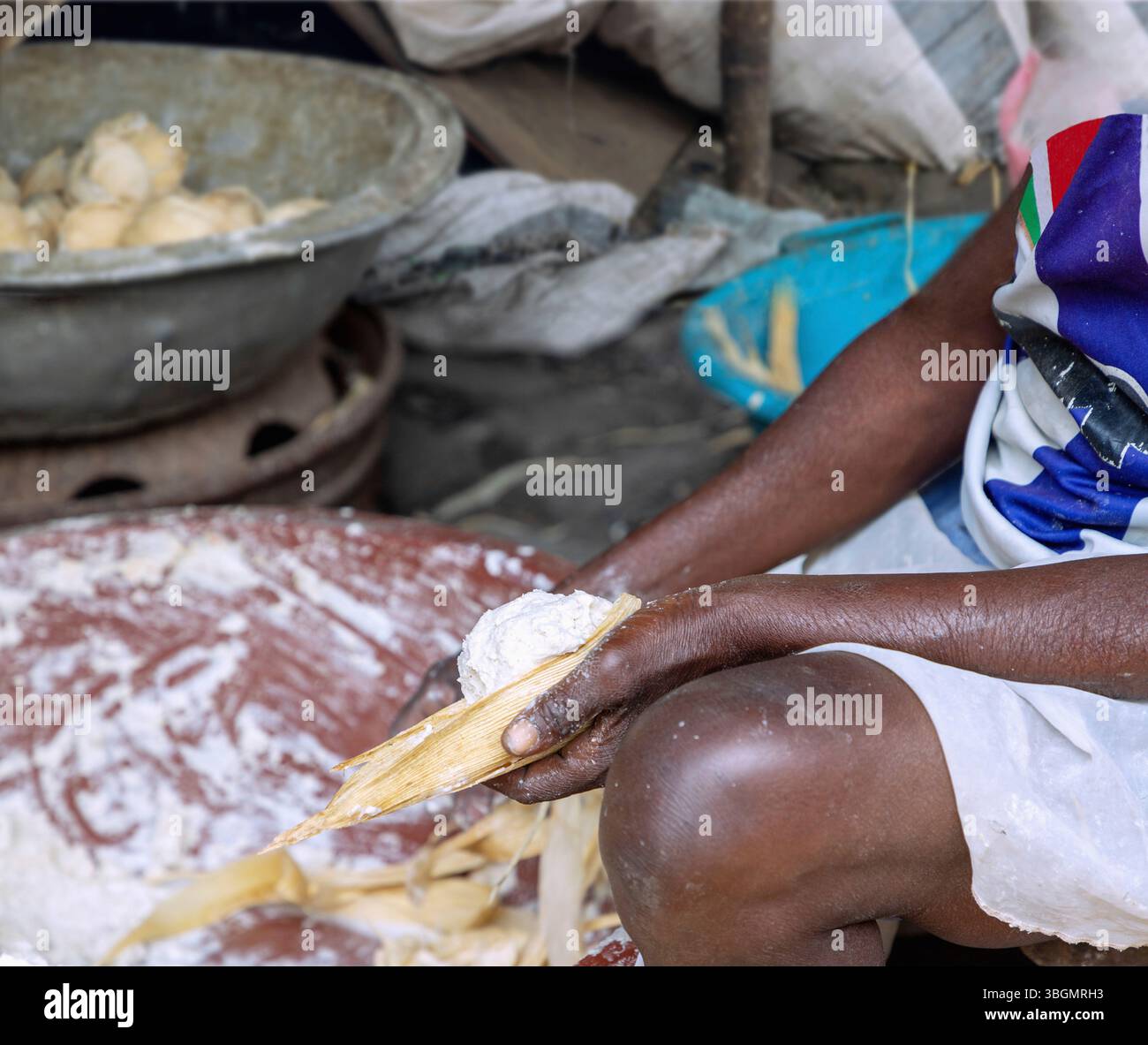 Woman preparing kenkey, soured maize balls in banana leaves in Teshie-Nungua in the Greater Accra region of eastern Ghana in West Africa Stock Photo
