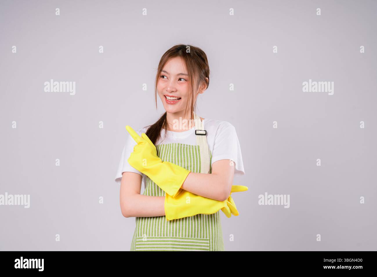 Woman job working wearing a yellow apron and gloves is pointing. She is ...