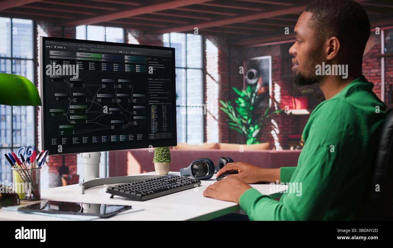 African american software developer does visual coding and creating software, implementing algorithms. IT expert at home working with notes tree and code language, app performance. Camera B. Stock Photo