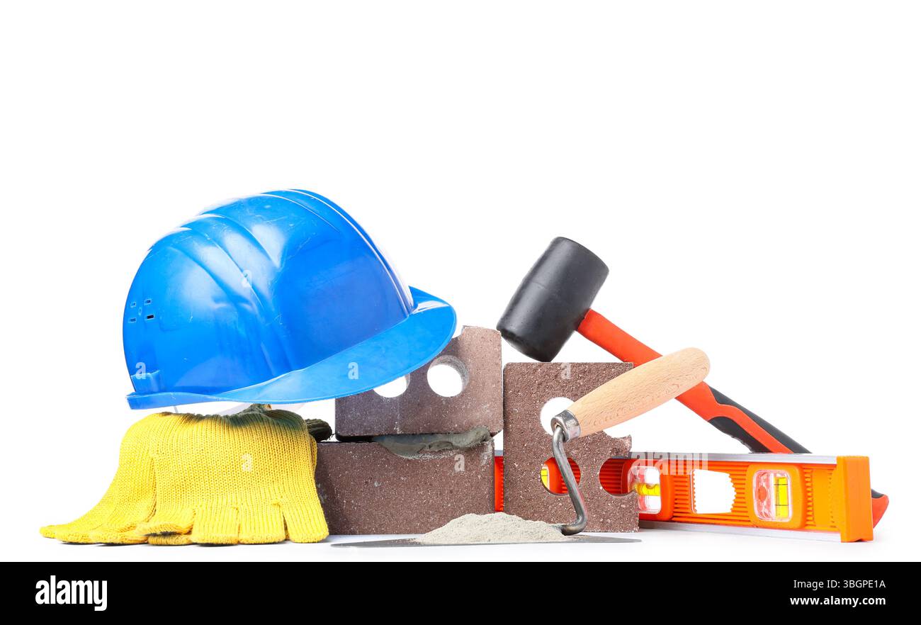 Hardhat, bricks and construction tools with cement on white background Stock Photo