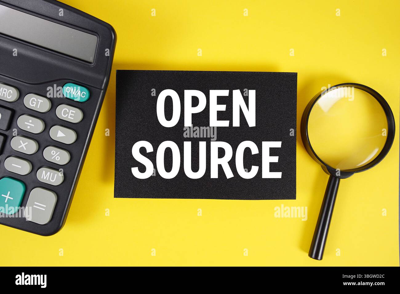Open Source text with magnifying glass anc calculator on yellow background Stock Photo