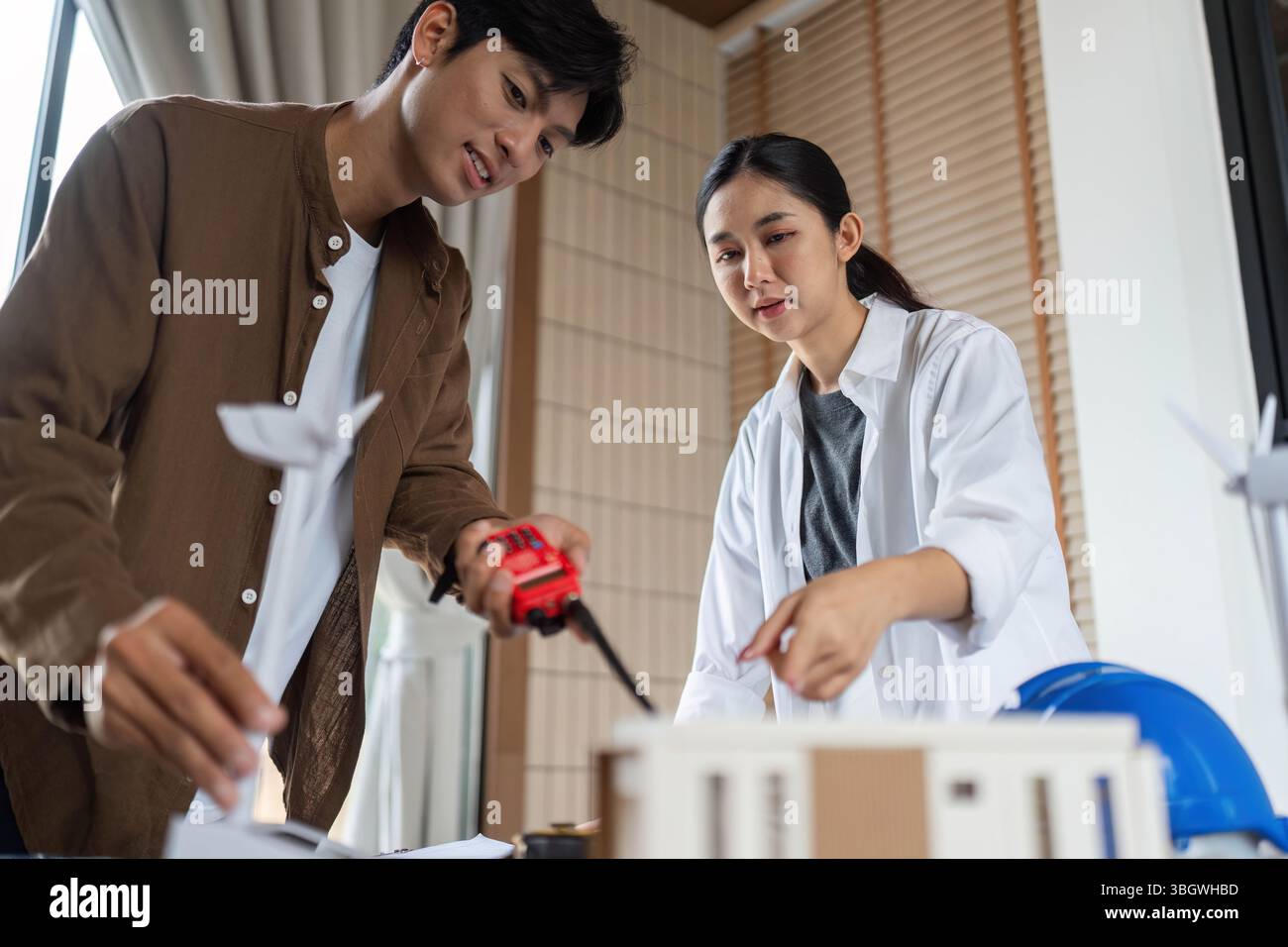 ESG Focused Teamwork. Architects collaborating on a sustainable model project. Stock Photo