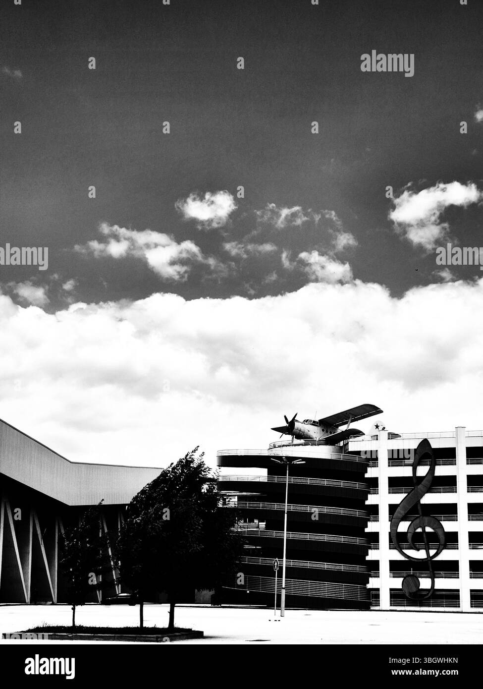 Biplane, multi-storey car park and large treble clef symbol. black and white photo - Smartphone Captured Stock Image
