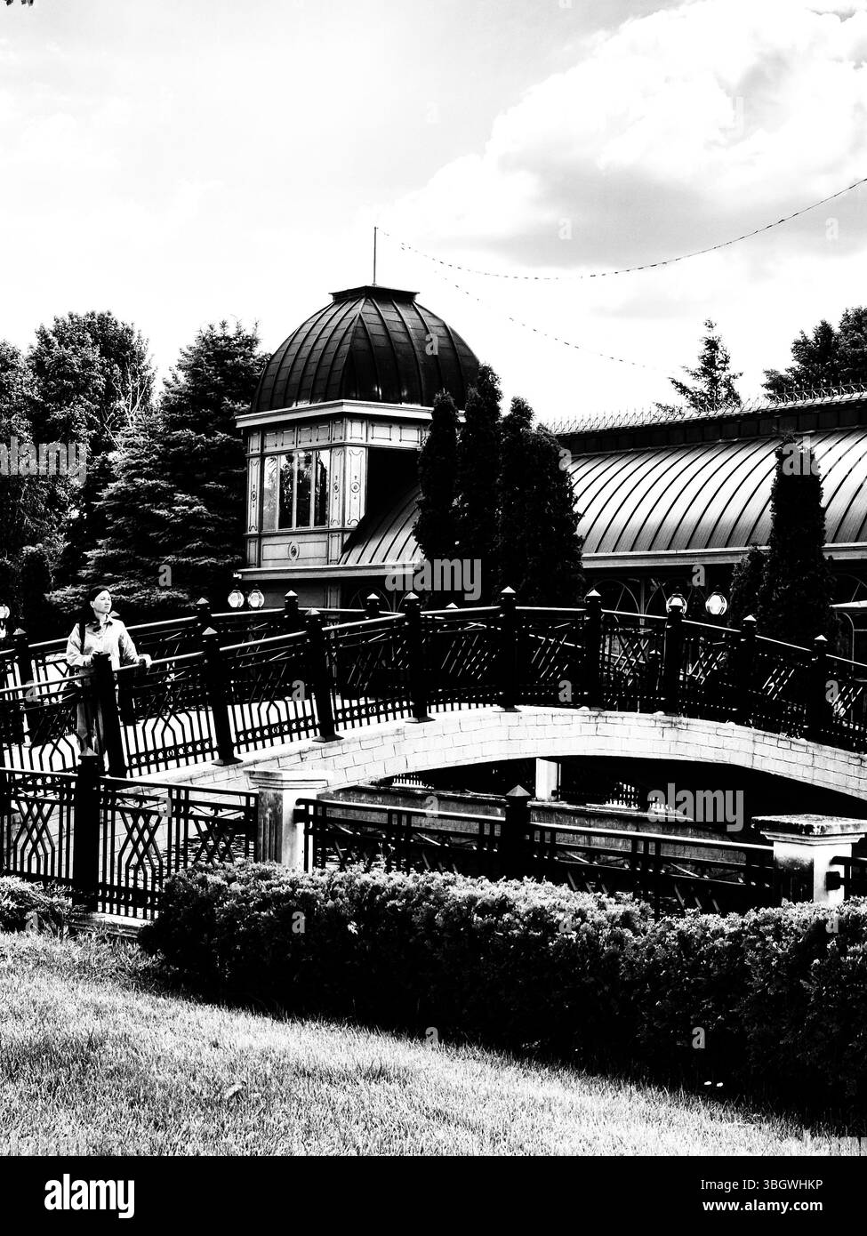 Architectural beauty with domes and bridge. woman on bridge looking at the scenery. black and white photo - Smartphone Captured Stock Image