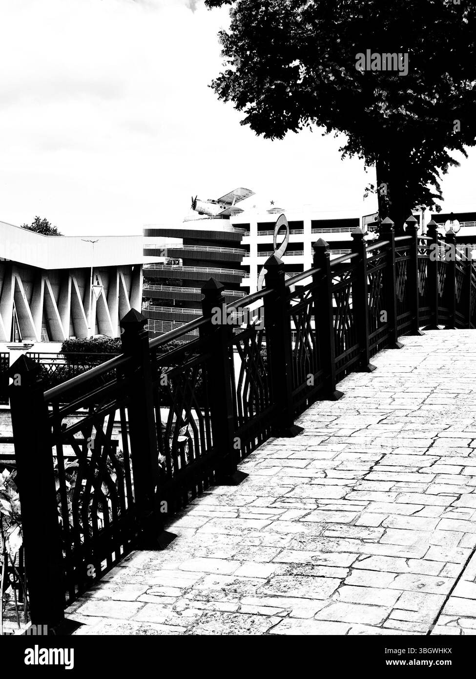 Biplane, multi-storey car park and large treble clef symbol. black and white photo - Smartphone Captured Stock Image