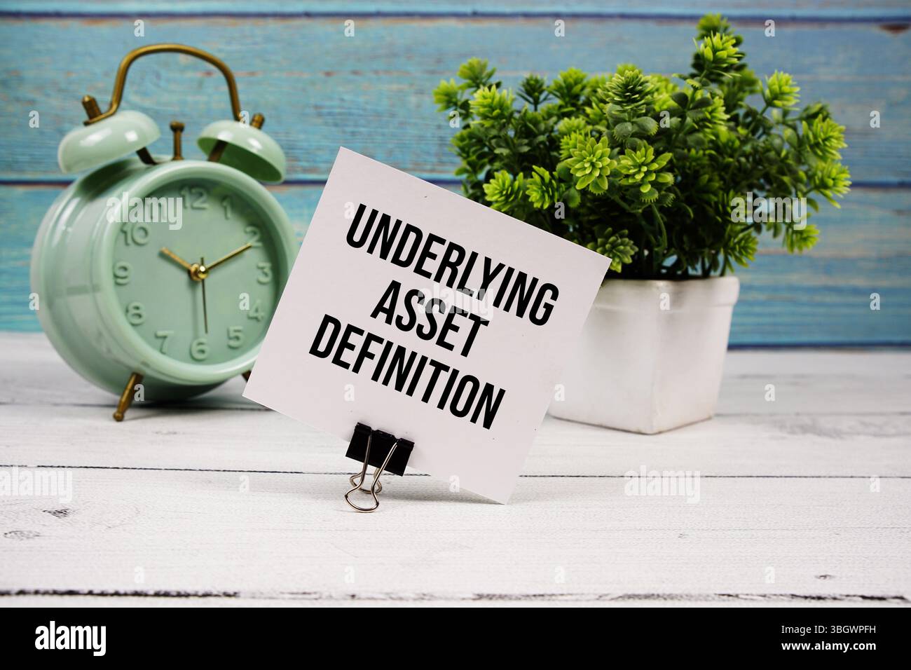 Underlying Asset Definition text written on paper card with alarm clock on wooden background Stock Photo