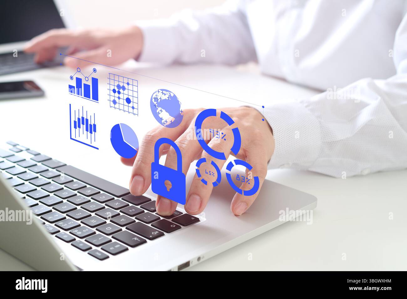 Close-up of a businessman's hands working on a laptop with digital security icons and data analytics graphics overlay, representing cybersecurity, dat Stock Photo