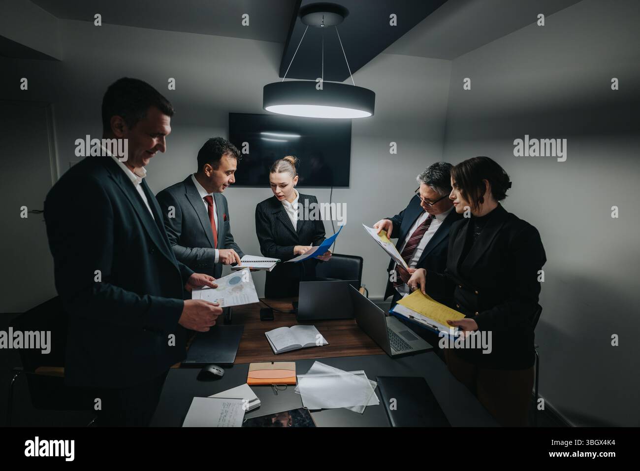 Business professionals gathered around a table for a focused meeting session Stock Photo