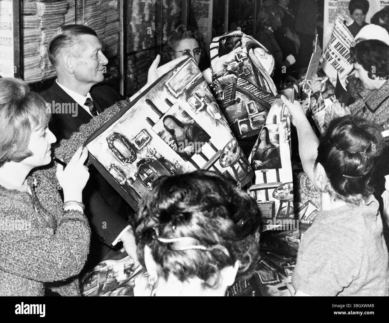Customers buying dish towels with images of the Mona Lisa on an easel in an artists studio from a department store in Paris. 11 January 1963    [caption in French] Stock Photo