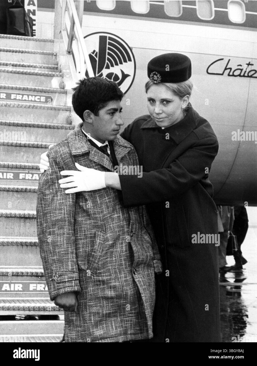 Soterios Maimaris (left) was born with a heart defect and was escorted from an Air France jet by ground hostess Marie-Clair Schuerweth. 12 December 1967 Stock Photo
