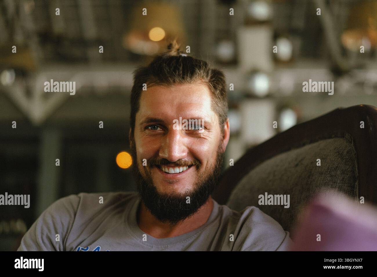 Smiling man relaxing indoors in soft natural light Stock Photo