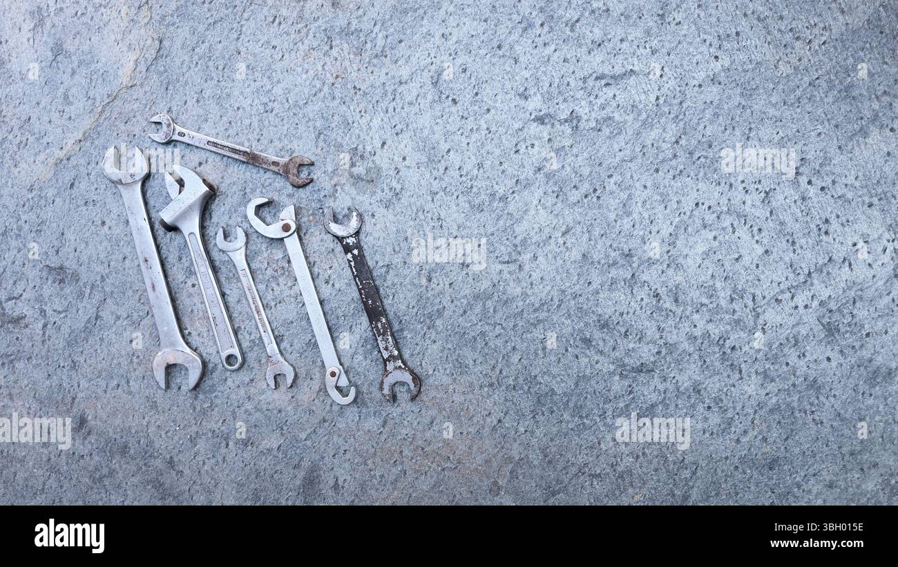 Different wrenches and professional tools lying on a concrete surface, ready for mechanic work Stock Photo