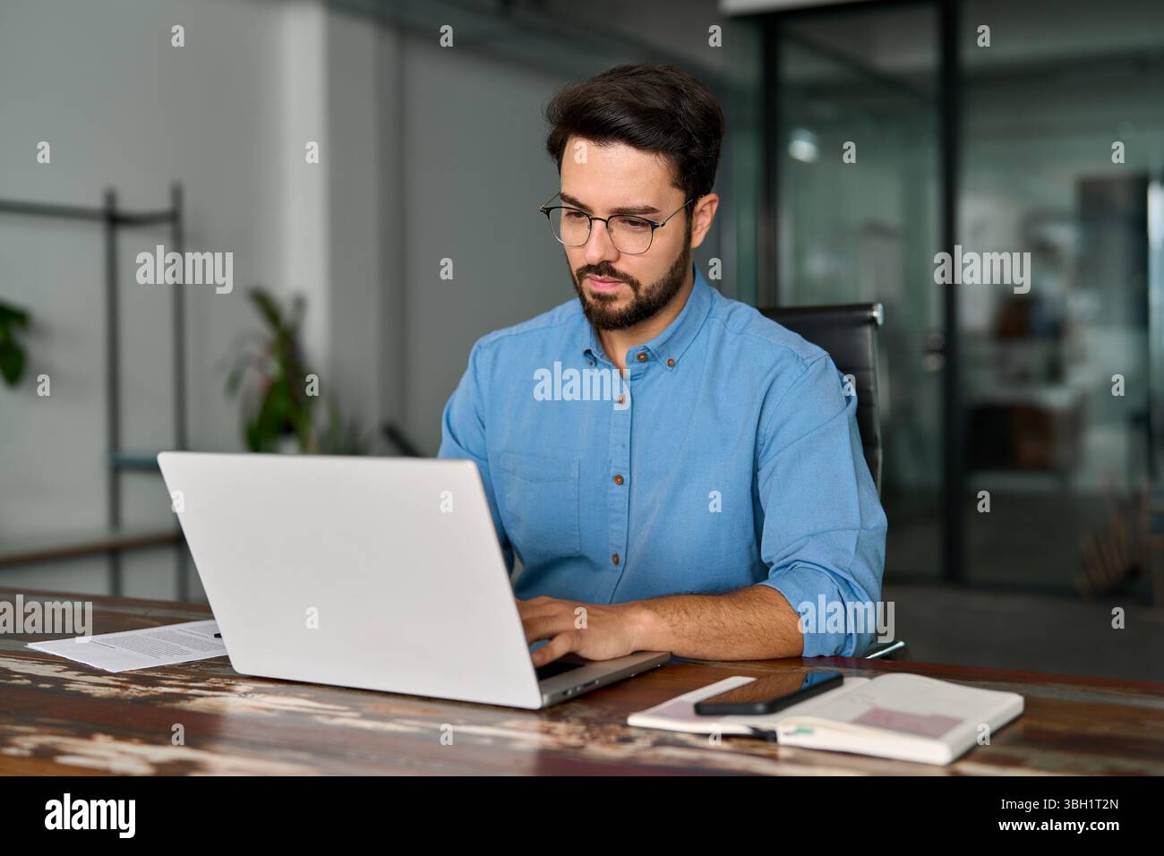 Busy professional business man using laptop working in office. Stock Photo