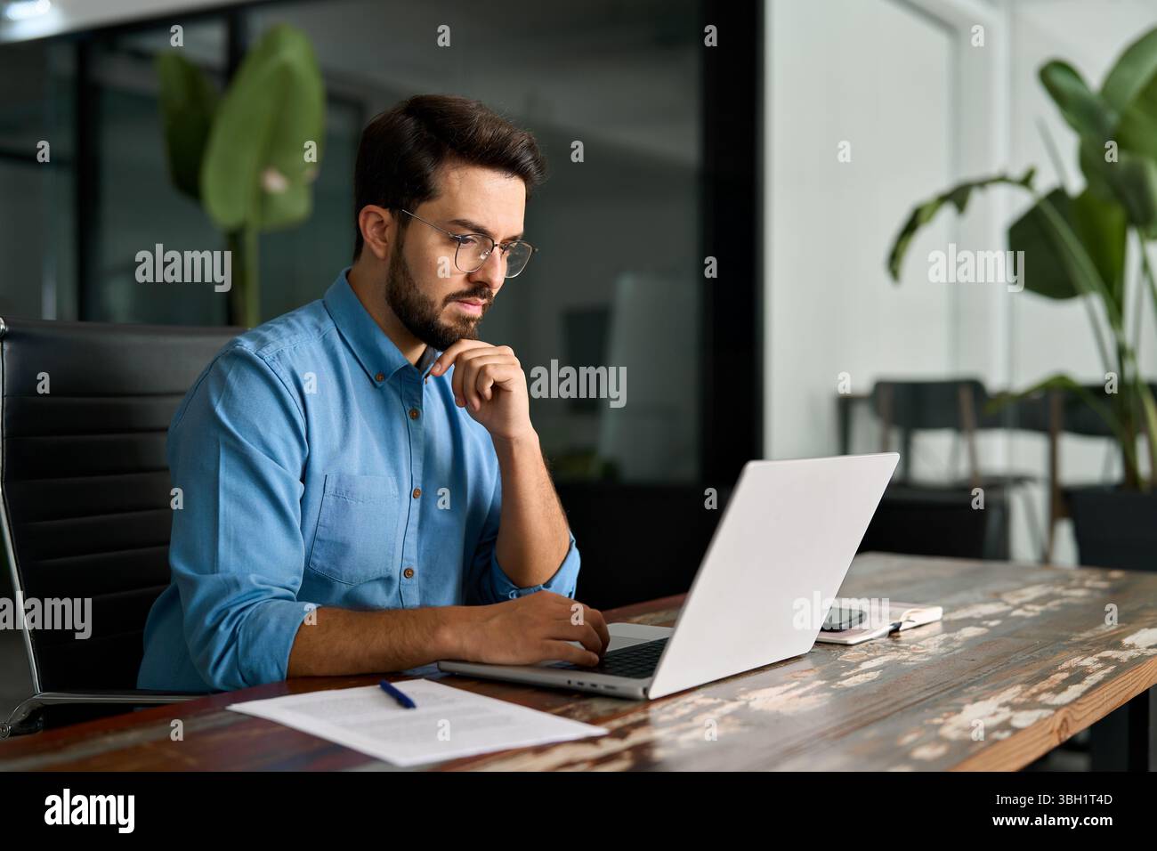 Busy business man thinking on online investment working on laptop. Stock Photo