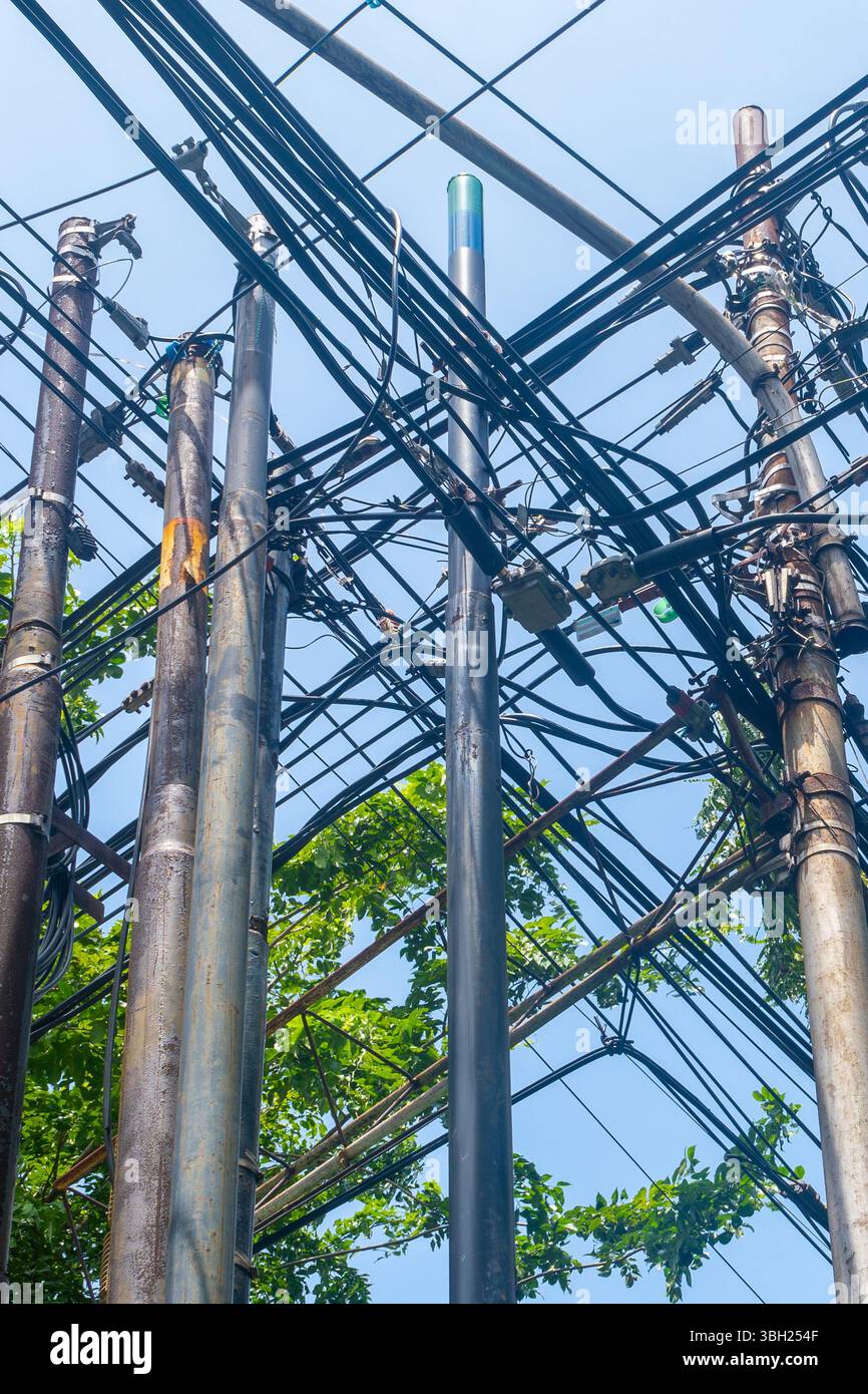 Bunch of power lines are tangled together. The sky is clear and blue ...