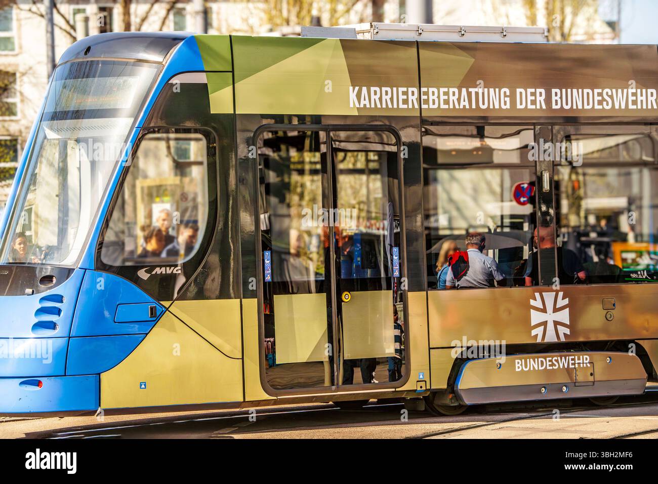 Straßenbahn mit Bundeswehr-Werbung am Romanplatz, München, April 2025 Deutschland, München, April 2025, Straßenbahn mit Bundeswehr-Werbung hält am Romanplatz, Werbung für eine Bundeswehrkarriere, Karriereberatung der Bundeswehr, Trambahn in Tarnfleck, MVG, ÖPNV, Bayern, *** Streetcar with Bundeswehr advertising at Romanplatz, Munich, April 2025 Germany, Munich, April 2025, streetcar with Bundeswehr advertising stops at Romanplatz, advertising for a Bundeswehr career, Bundeswehr career advice, streetcar in camouflage, MVG, public transport, Bavaria, Stock Photo