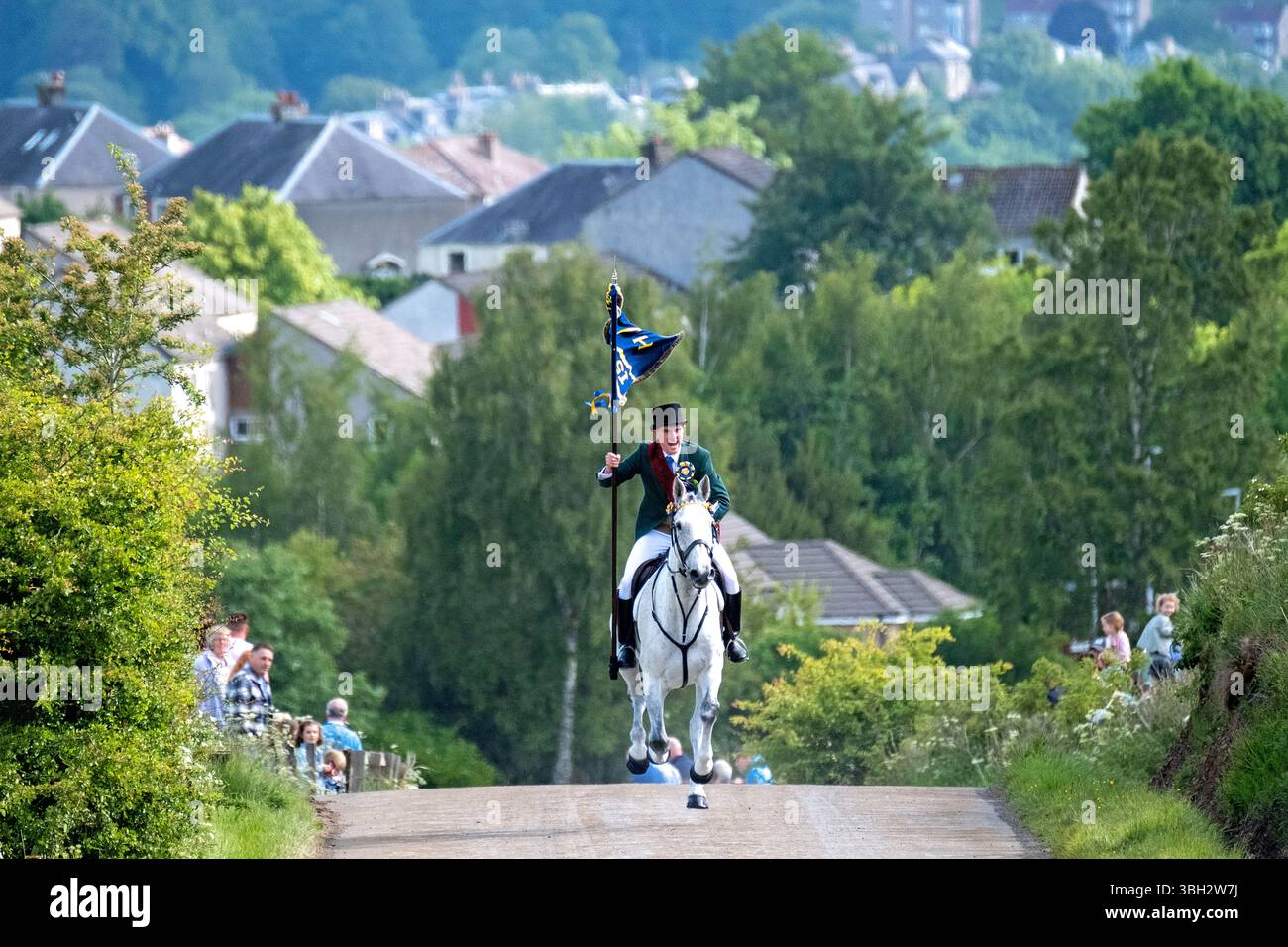 Hawick, UK. 06th June, 2025. Friday 6 June 2025 Hawick Common Riding 2025, Cornet Jack Scott, gallops up the Nipknowes on the unmarried mens chase towards St Leonards, proudly carrying “The Banner Blue”. Hawick Common Riding is the first of the annual Border events, it celebrates the capture of an English Flag from a raiding party in 1514 by the youth of Hawick at Hornshole and the ancient custom of riding the marches or boundaries of the common land. Credit: Rob Gray/Alamy Live News Stock Photo