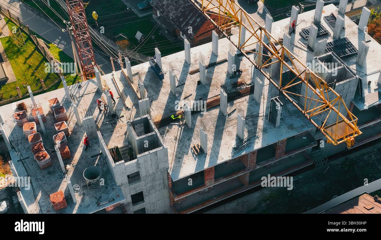 High-rise construction site with crane and workers. Aerial view of a ...