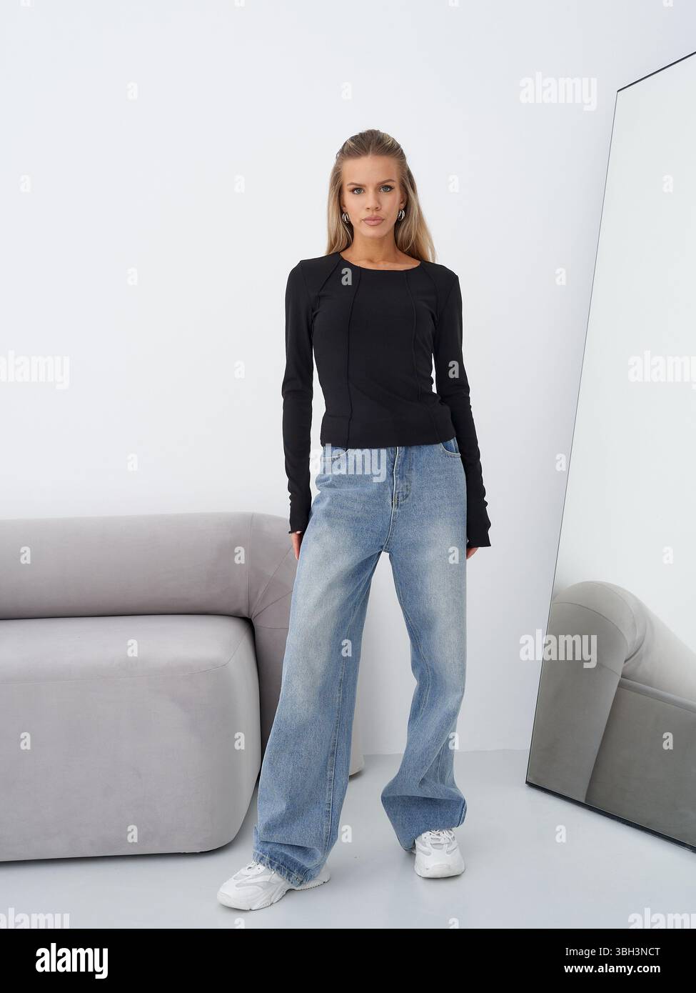 Stylish blonde model poses in trendy outfit inside modern studio Stock ...