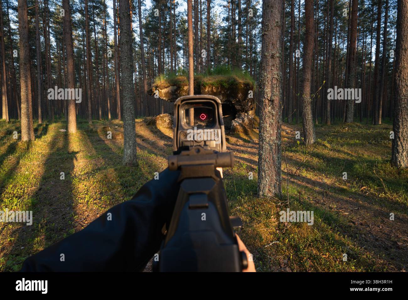 Aiming an assault rifle with a holographic sight in a forest, first ...
