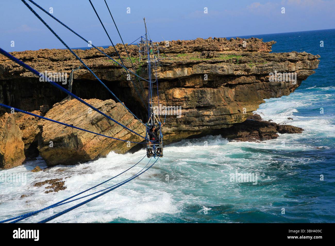 Using their own traditional cable car, shrimp fisherman cross the island every day to catch shrimp on the edge of a cliff. Stock Photo