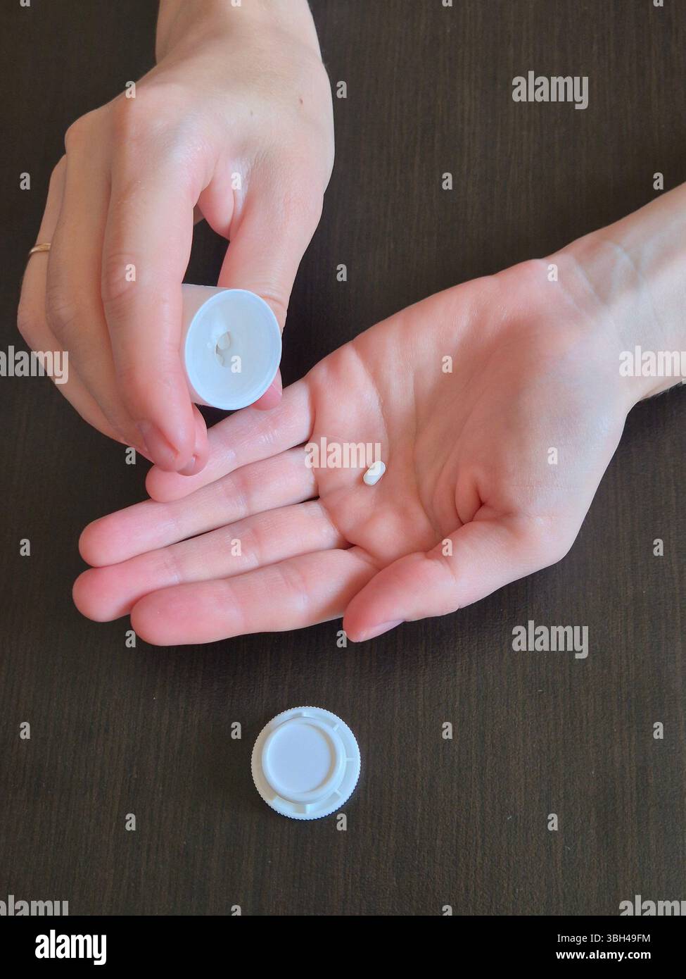 hand holds pills. in hands a jar with pills, drugs. small white pill in hand - Smartphone Captured Stock Image