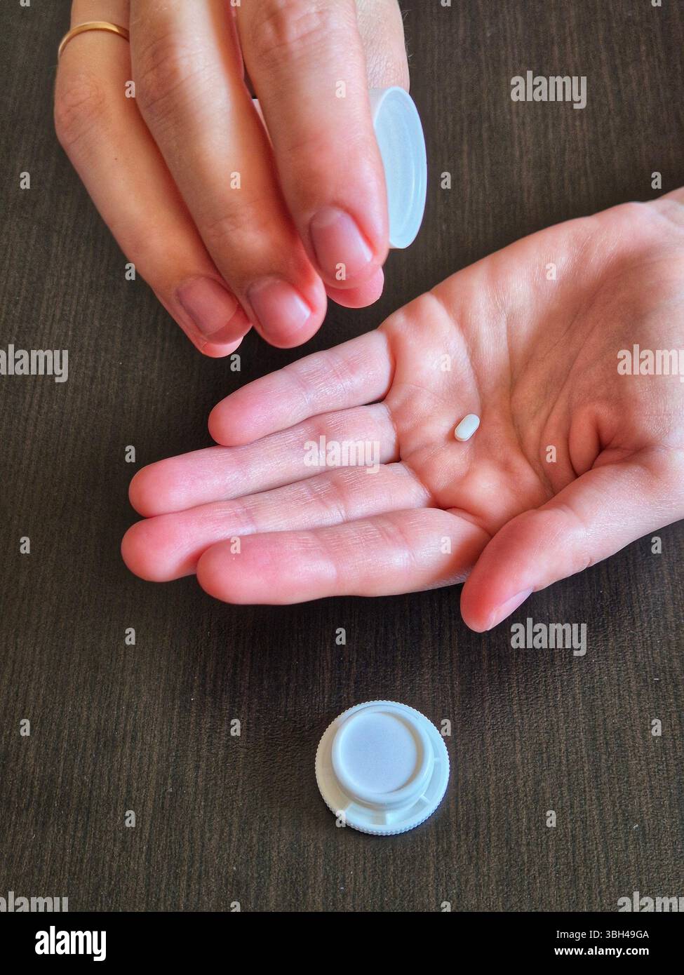 hand holds pills. in hands a jar with pills, drugs. small white pill in hand - Smartphone Captured Stock Image