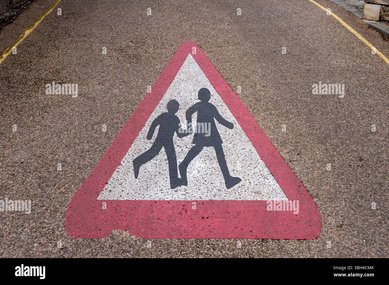 Warning Sign Depicting School Crossing on a Rough Textured Road Surface ...
