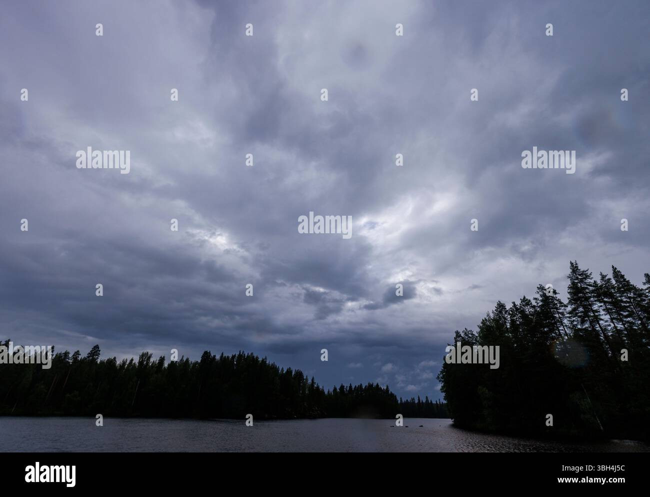 Gray rain clouds over Finnish forest lake at Summer, Finland Stock Photo