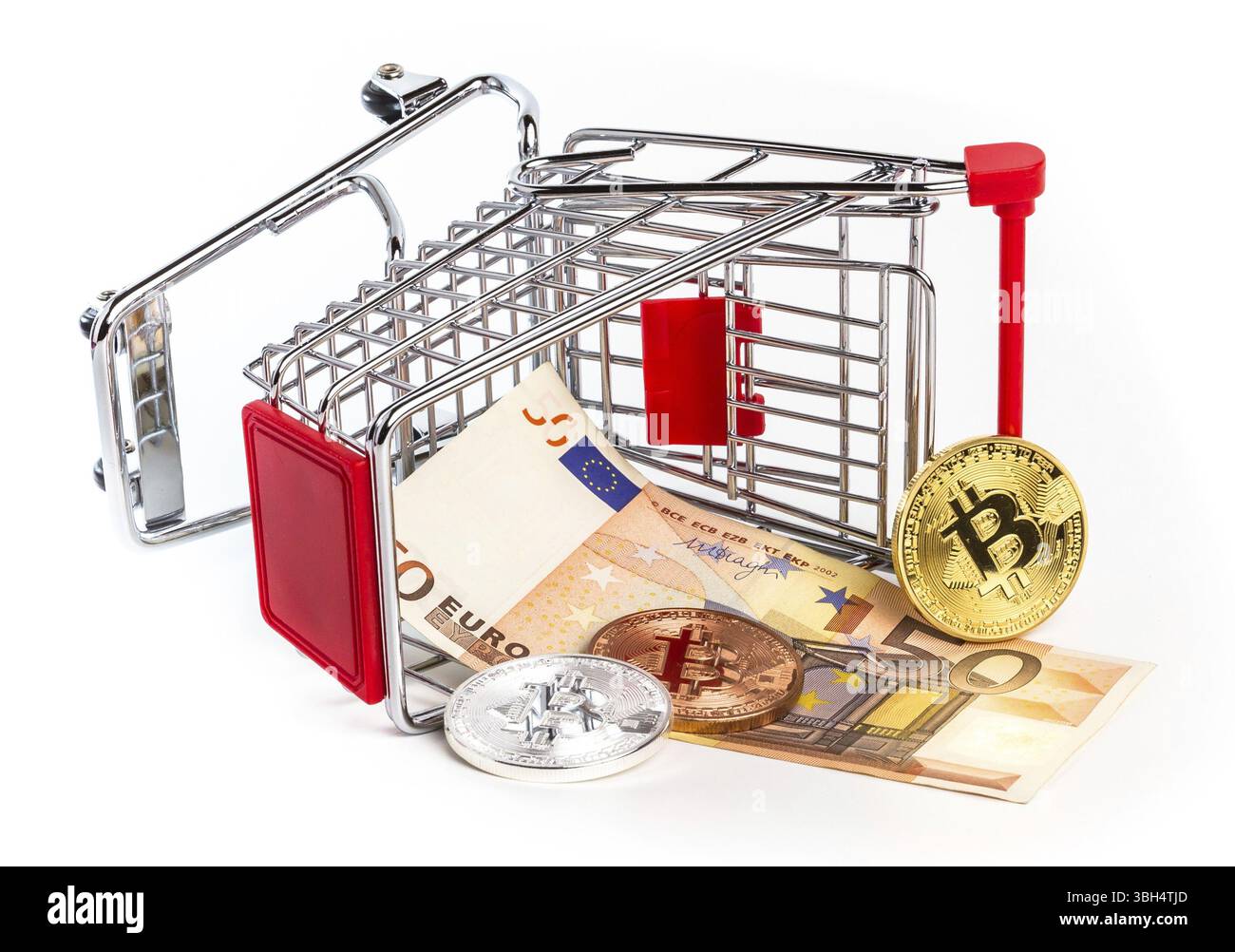 Euro and physical metal bitcoins in overturned toy trolley. Business concept, wrong investment, crisis. Traditional money versus cryptocurrency concep Stock Photo