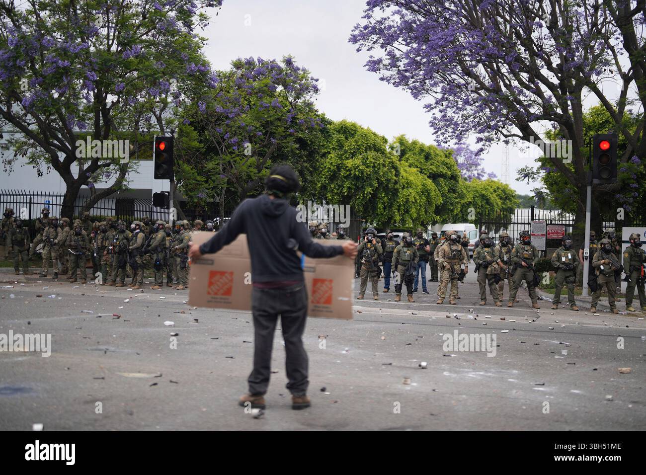 Section 7 Lock Riot A protesters holds a sign as Border Patrol personnel in riot gear and ...