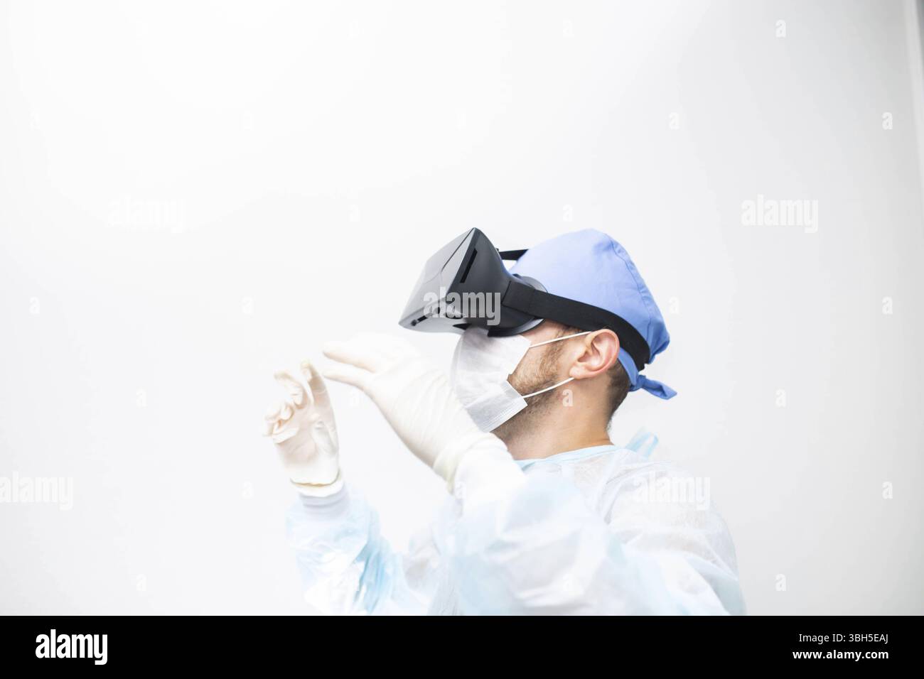 Individual in medical attire using VR headset, exploring technology Stock Photo