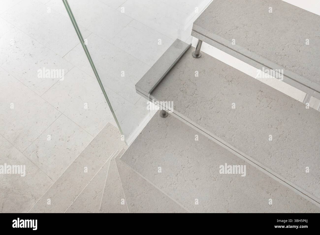 Microcement Railing Grey microcement stairs with glass handrail. Stairs viewed from above ...