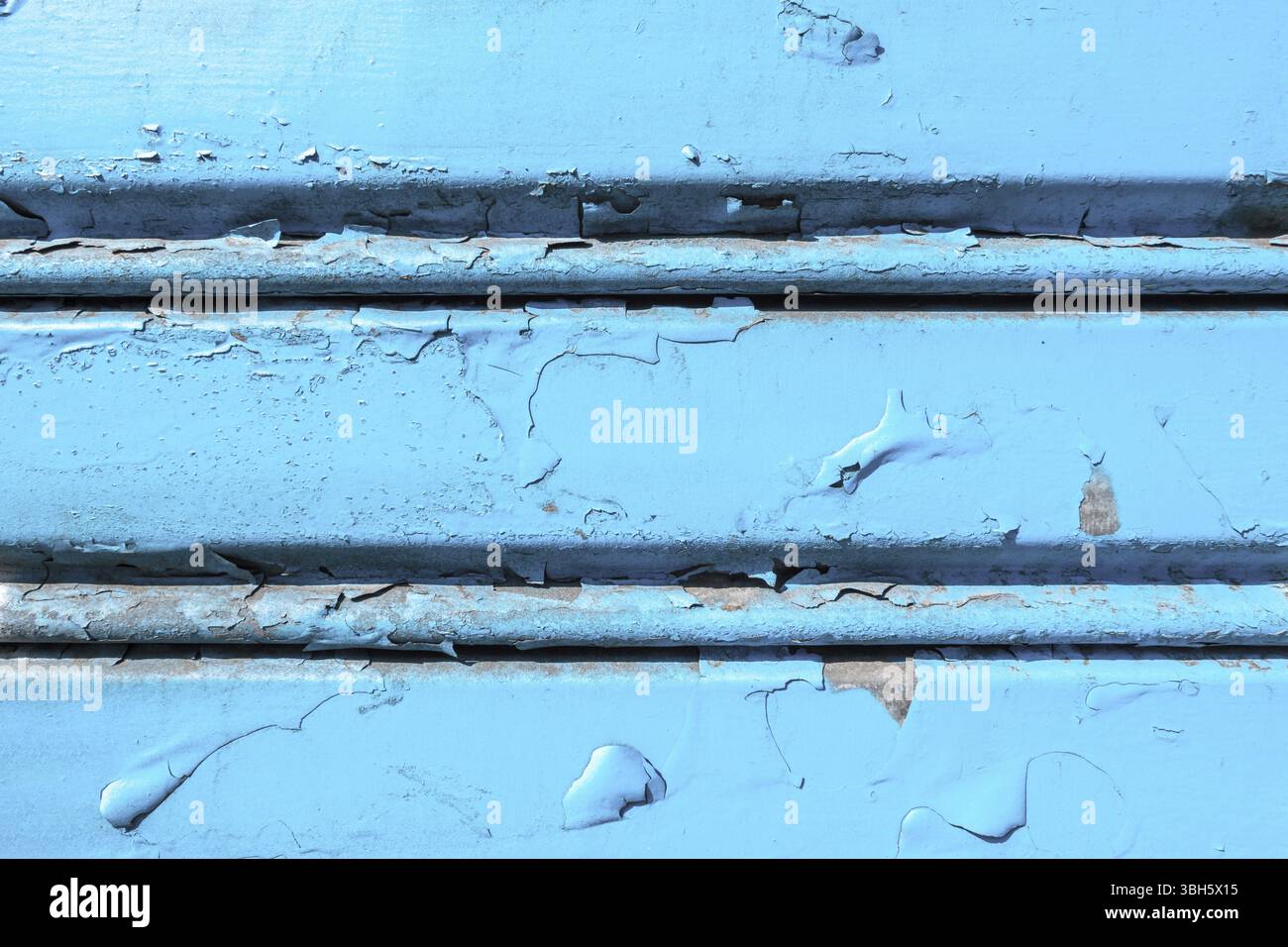 Background of old metal sheet with peel paint texture surface. Painted metal roller shutters door with peeling paint dirty blue hue. Grungy background Stock Photo