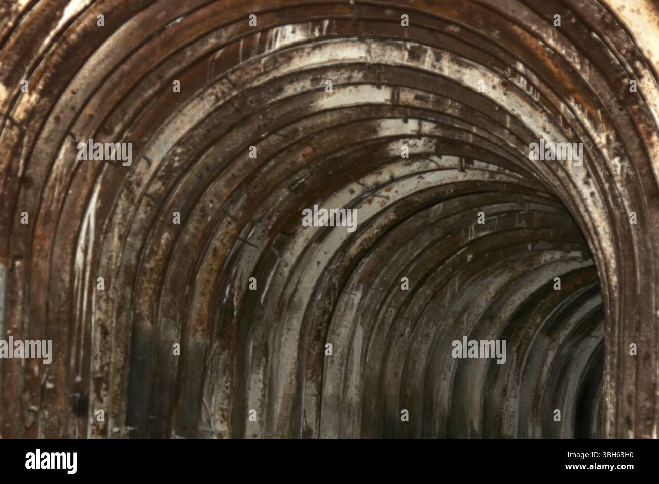 An old tunnel with an arched metal beams in mauntain Stock Photo