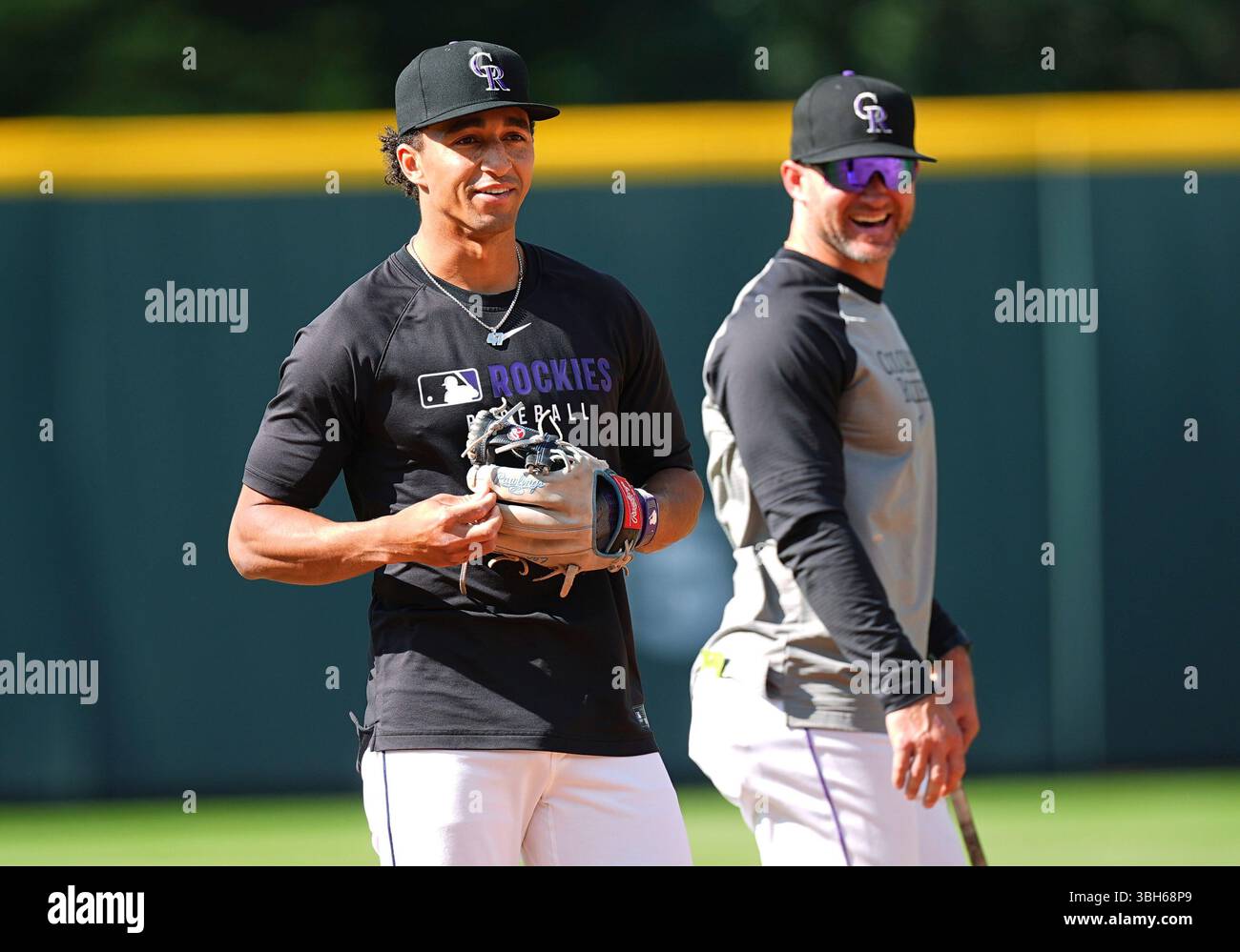 Colorado Rockies shortstop Ryan Ritter, front, warms up as interim ...