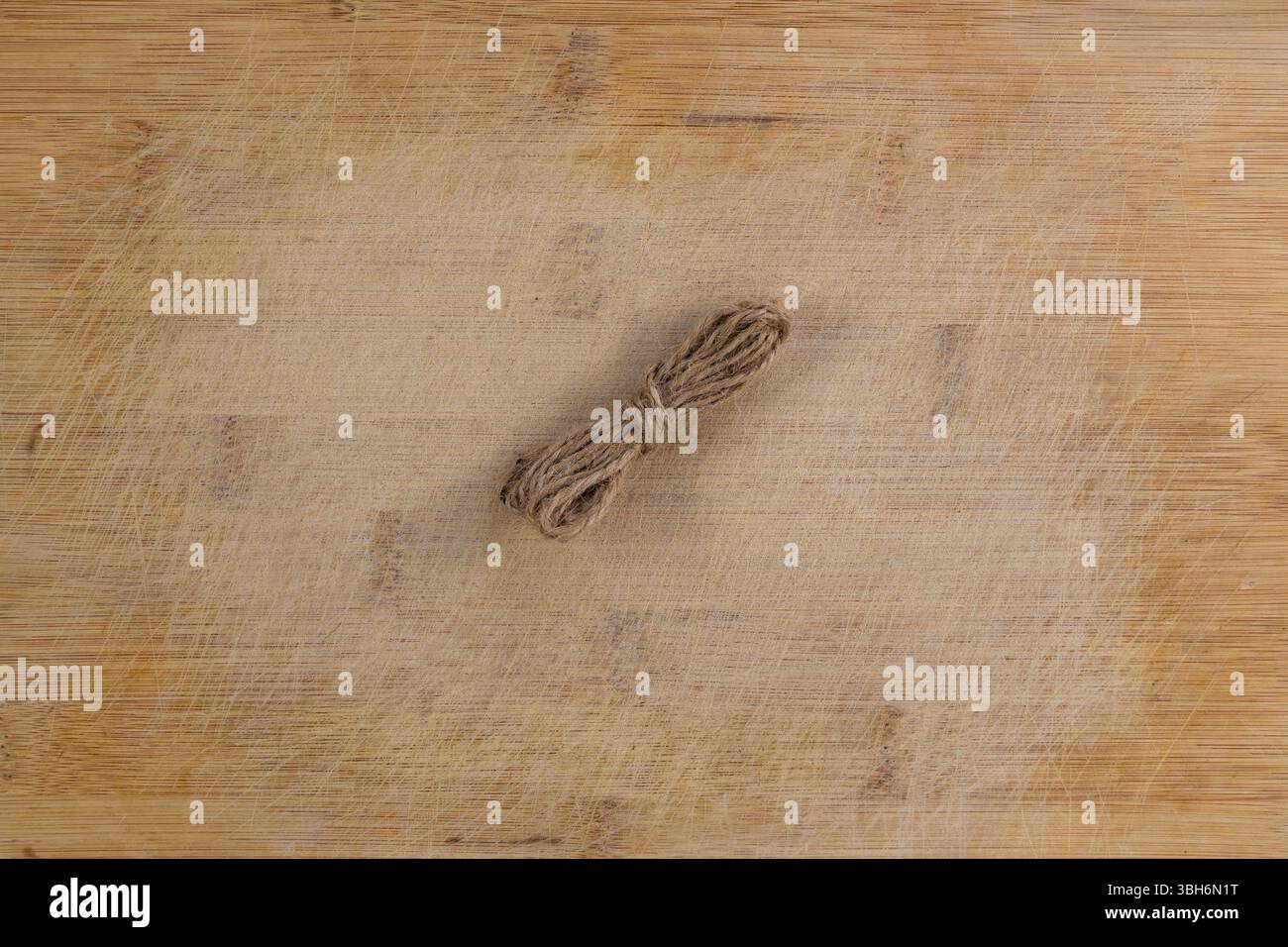 Twine Roll on Rustic Scratched Wooden Table Stock Photo
