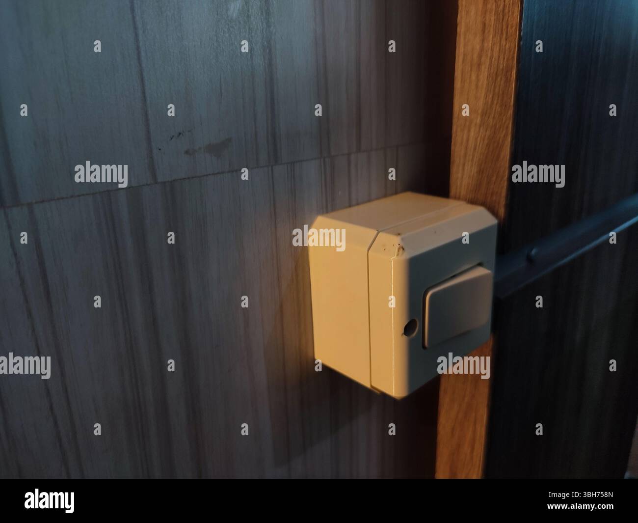 'Close-up of a white light switch mounted on a plain wall. The minimalistic design and neutral color make it suitable for residential or office interior concepts. - Smartphone Captured Stock Image