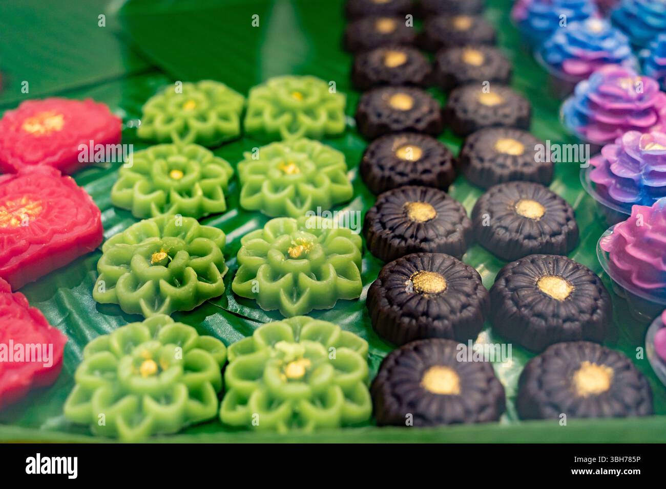 Display of intricately crafted Thai desserts called Khanom Chor Muang. Stock Photo