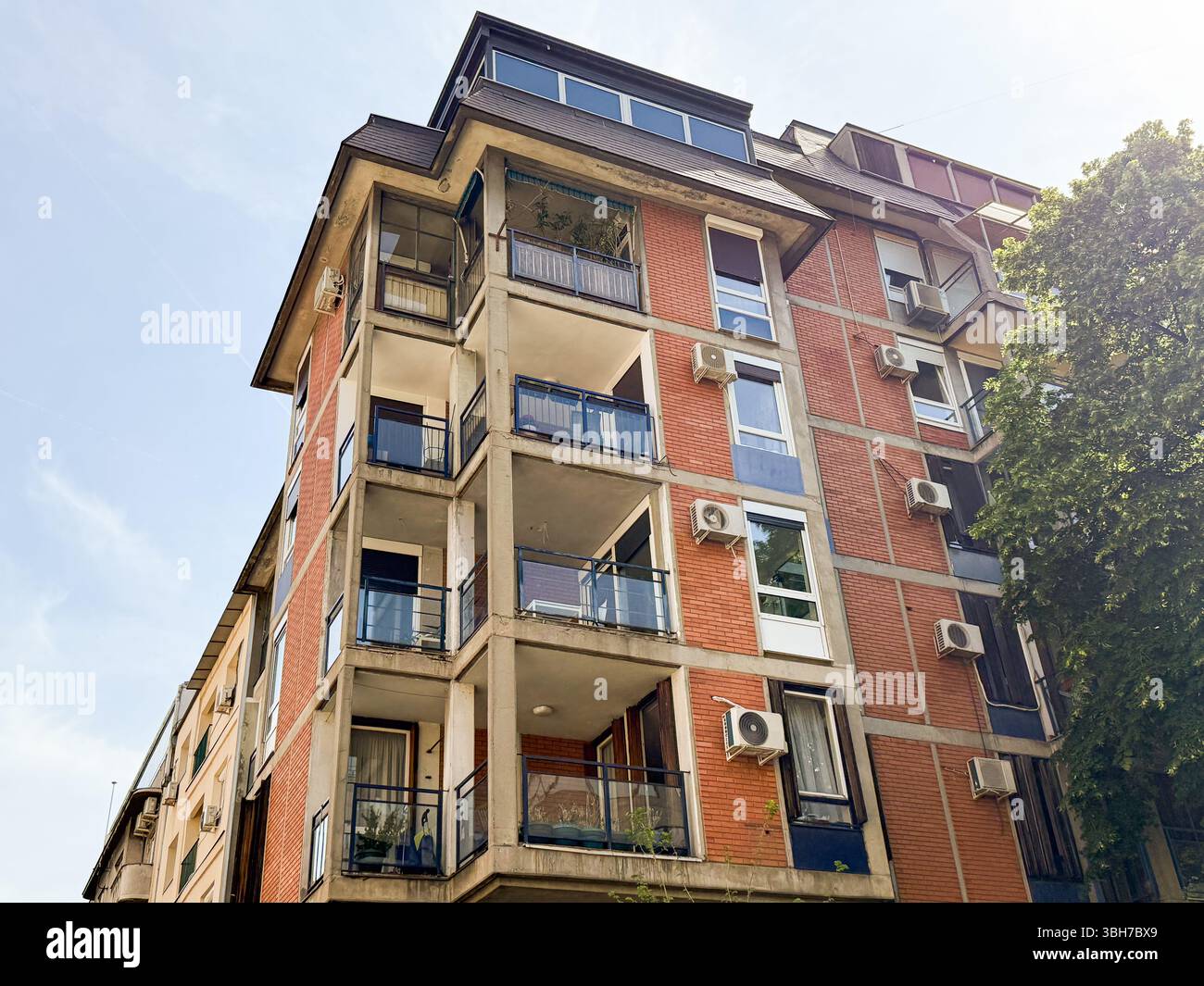 Residential building with balconies and red brick facade. Multi-story ...