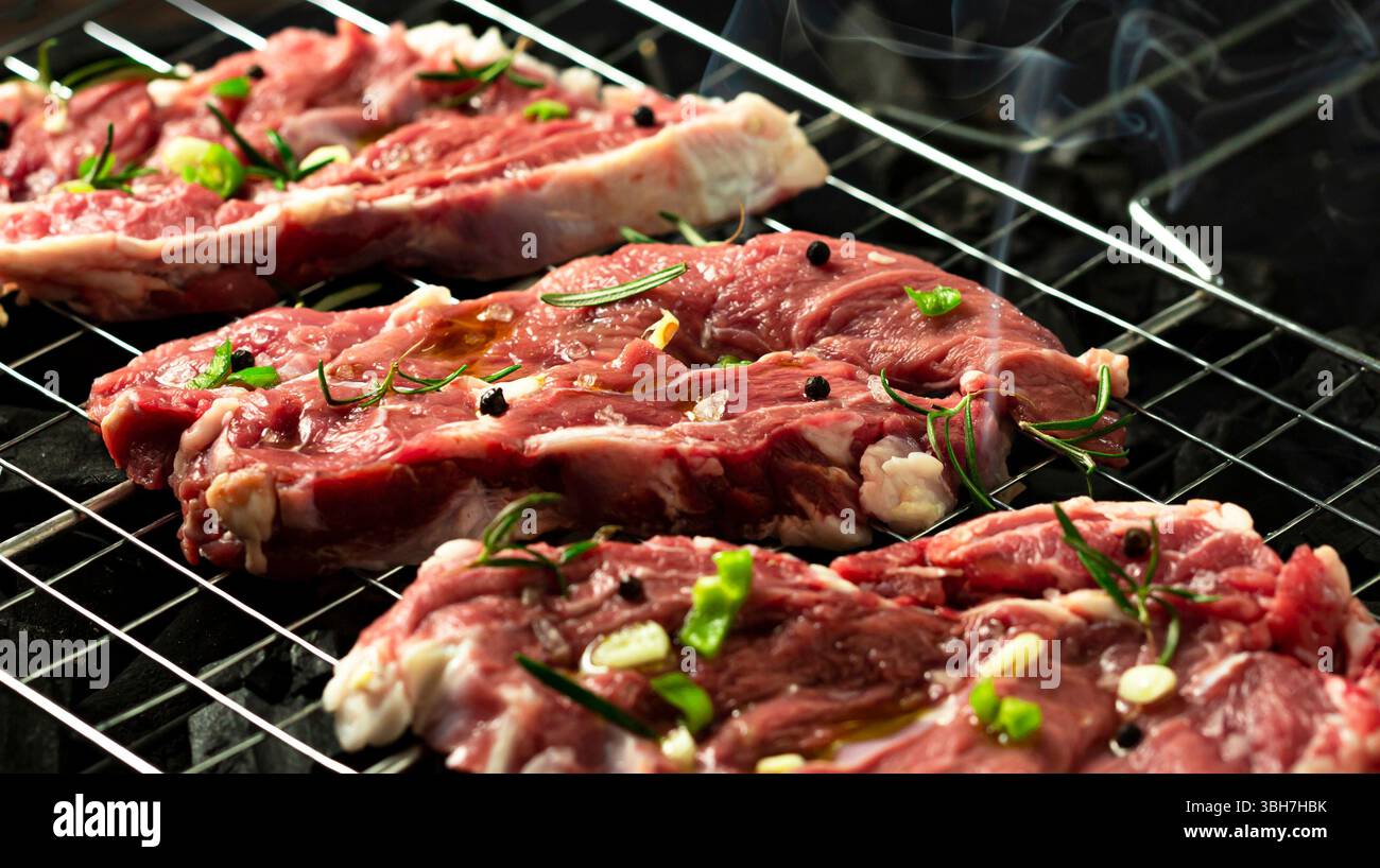Veal steak on grill rack, dark background. Stock Photo
