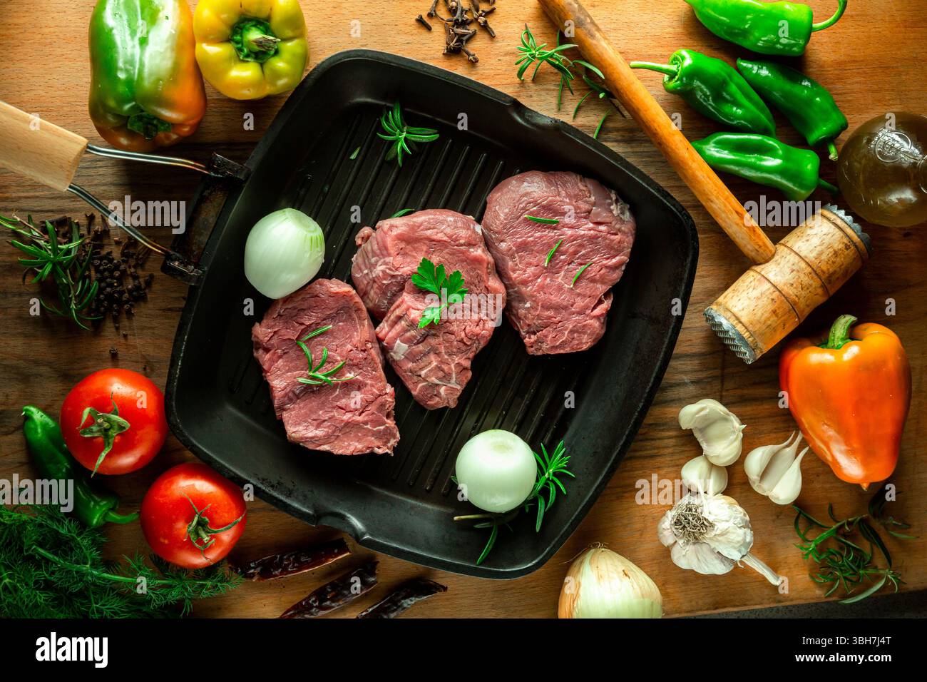 Fresh raw veal steak in pan with vegetables, top view. Stock Photo
