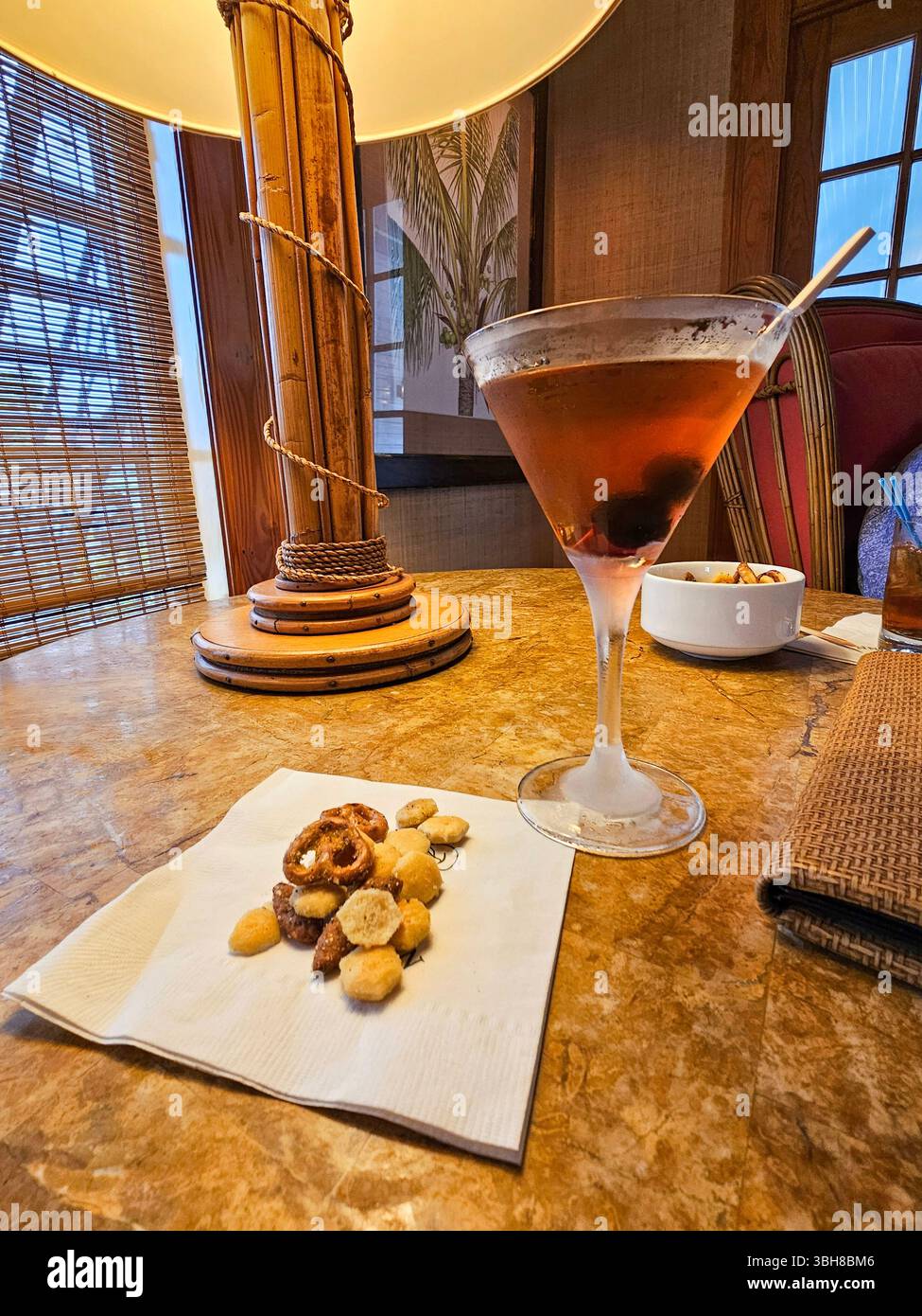 A manhattan with cherries and snacks at Gasparilla Inn, Boca Grande, Florida. The bar at the famous Gasparilla Inn is a gathering spot. - Smartphone Captured Stock Image