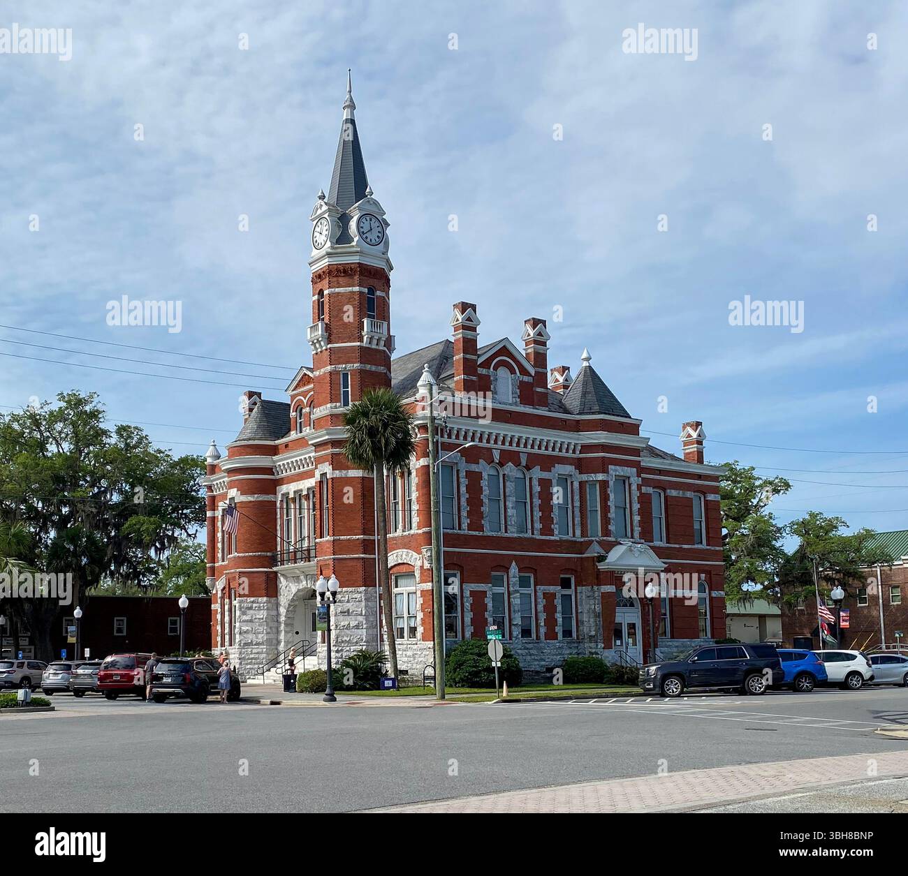 The granite and brick exterior of the historic Old City Hall with terra cotta friezes and a clock tower in Brunswick, Georgia - Smartphone Captured Stock Image