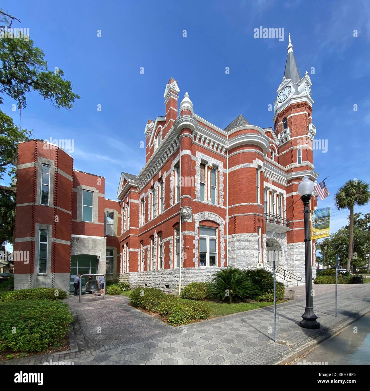 The granite and brick exterior of the historic Old City Hall with terra cotta friezes, gargoyles, and a clock tower in Brunswick, Georgia - Smartphone Captured Stock Image