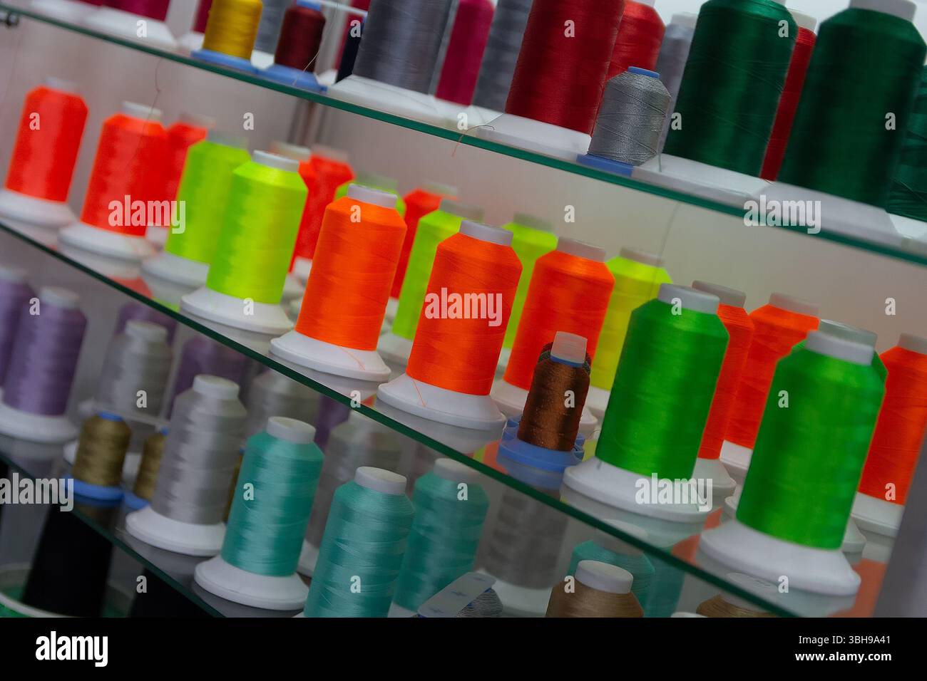 Colored embroidery spools with thread. Sewing industry Stock Photo